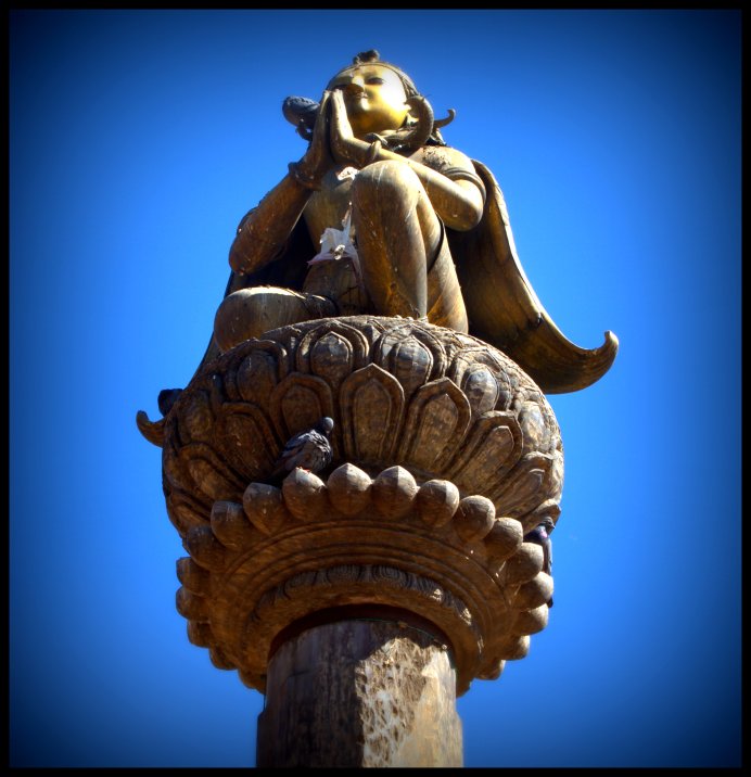A statue of Garuda overlooking one of the temples in the courtyard